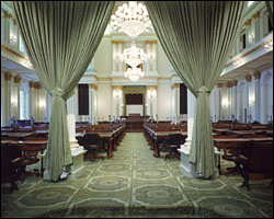 Hues of green and gold unify the Victorian neoclassic Assembly Chamber of the California State Capitol. The gold motto inscribed above the dais reads: “Legislatorum est Justas leges condere” (the legislator’s duty is to make just laws). The Wilton weave carpet is by the same manufacturer as the carpet of the House Chamber of the U.S. Capitol.