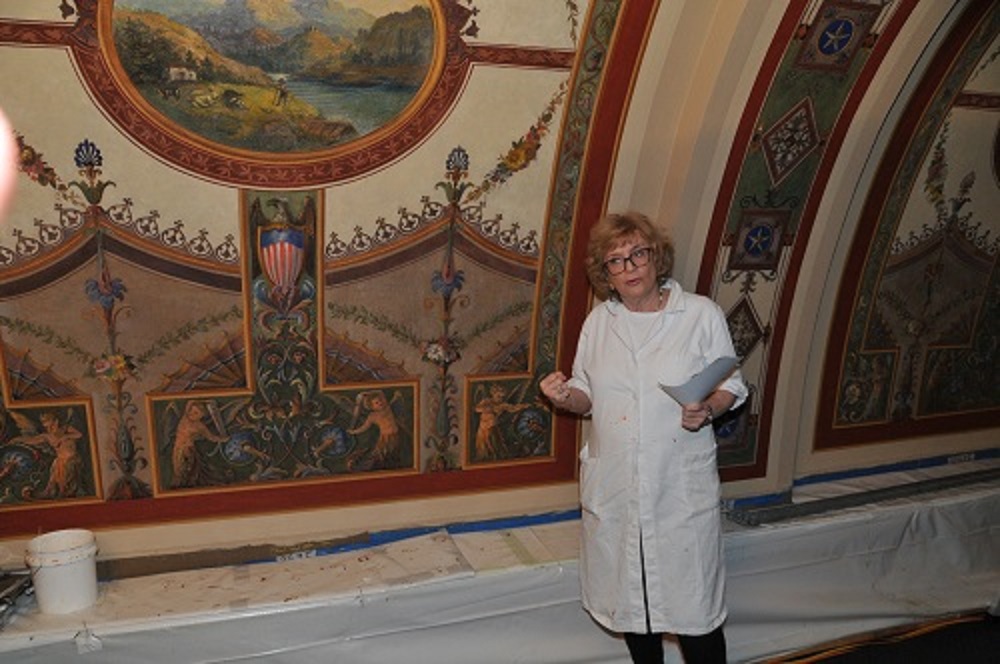 Christy Cunningham-Adams, Chief Conservator at Cunningham-Adams Conservation, shows off part of the ceiling that is to be restored
