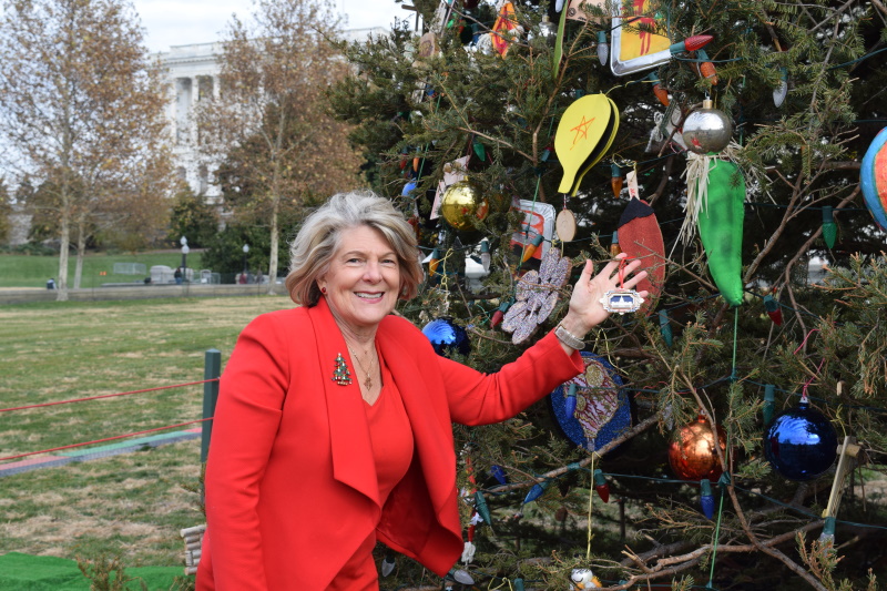 USCHS President/CEO Jane L. Campbell hangs the 2019 Ornament on the Capitol Christmas Tree